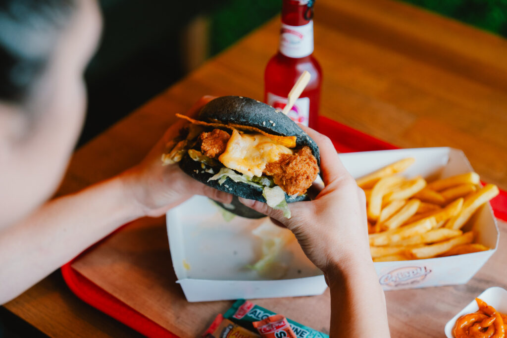 Weiblicher Gast, die einen Burger isst